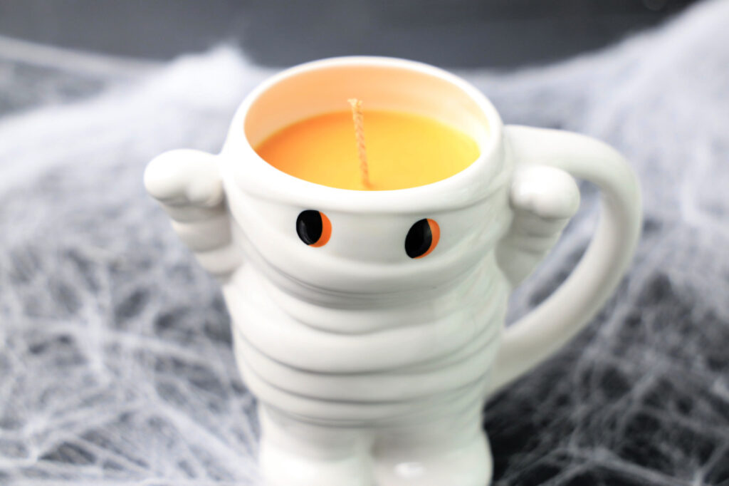 Mummy-shaped candle with orange eyes