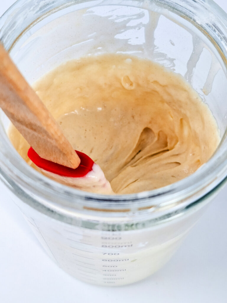 Thick, bubbly sourdough starter in jar