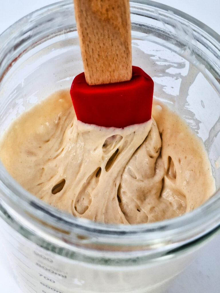 Thick, bubbly sourdough starter in jar