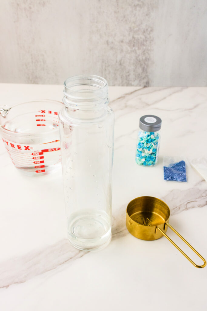 Empty bottle with colorful materials nearby