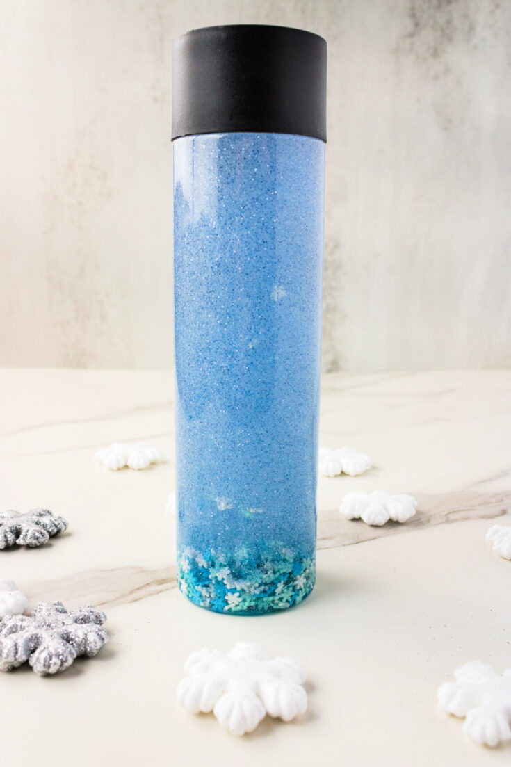 Blue glitter sensory bottle with snowflakes